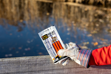 Load image into Gallery viewer, Honey bbq munchies held by gloved hand in front of water.