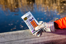 Load image into Gallery viewer, Teriyaki munchies held by gloved hand in front of water.