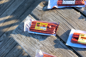 Mild and other flavor salami stix on picnic table.